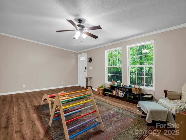 a living room with furniture floor to ceiling window and a flat screen tv