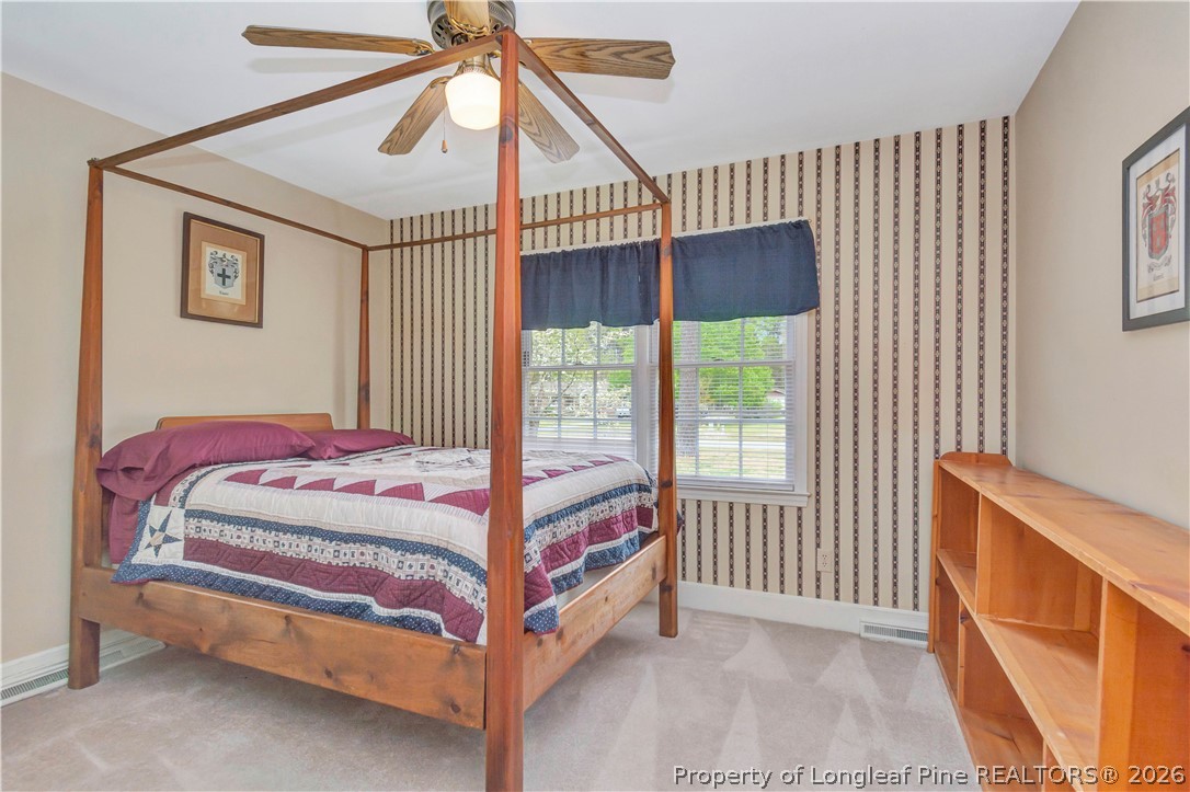 5219 McLeod Road Lumberton, NC 28358 - Photo 25 of 33 a bedroom with a bed and a chandelier