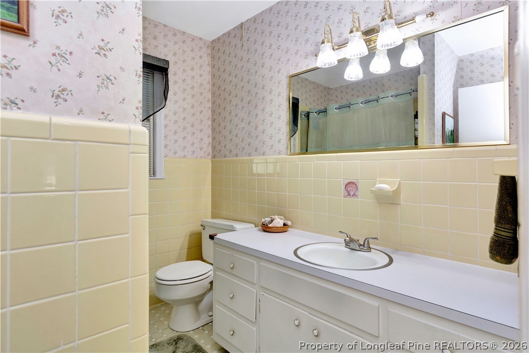 5219 McLeod Road Lumberton, NC 28358 - Photo 27 of 33 a bathroom with a granite countertop toilet sink and mirror