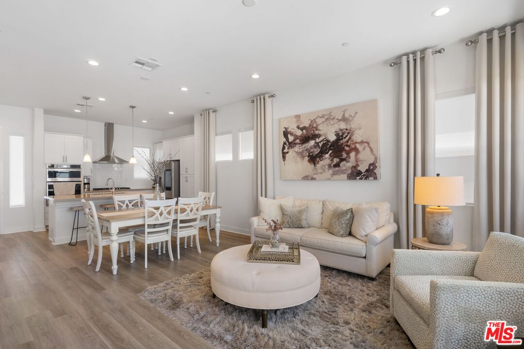 a living room with furniture kitchen and a table