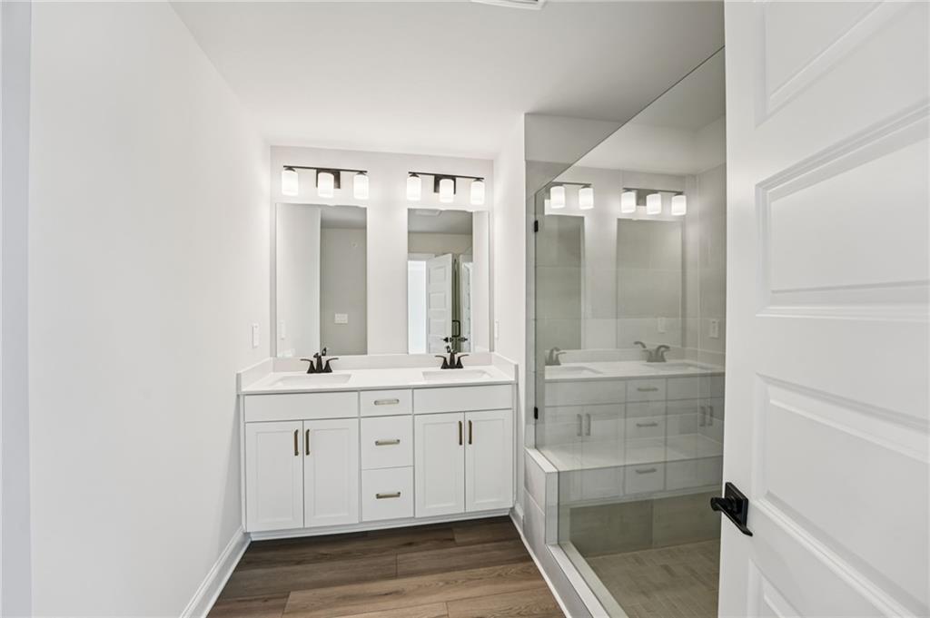 6450 Pinin Place Cumming, GA 30041 - Photo 45 of 53 a bathroom with a double vanity sink and mirror
