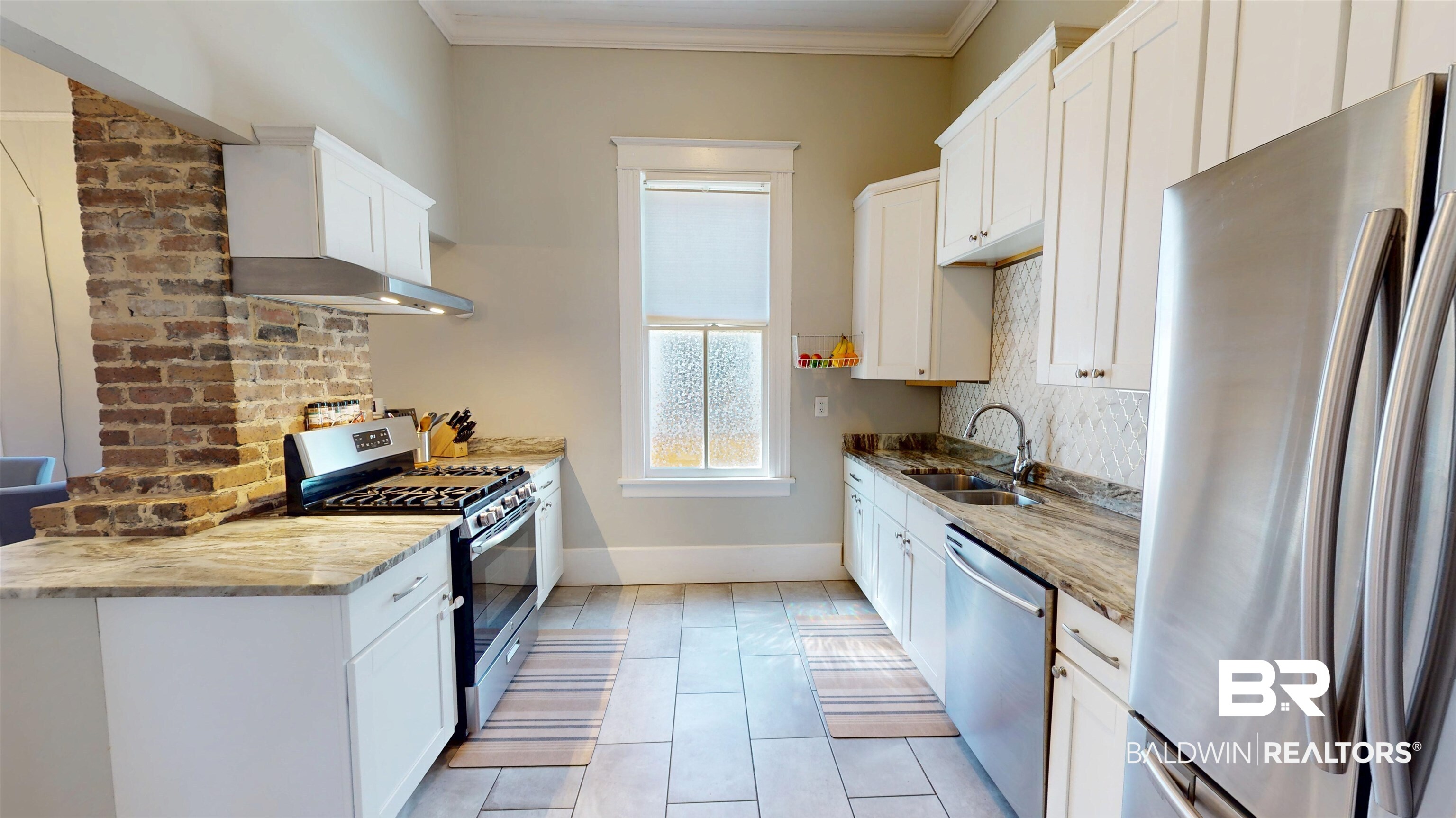 1154 New St Francis Street Mobile, AL 36604 - Photo 19 of 37 Kitchen featuring crown molding, baseboards, white cabinets, stainless steel appliances, and a sink