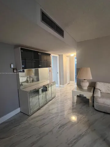 a living room with furniture a chandelier and a dining table