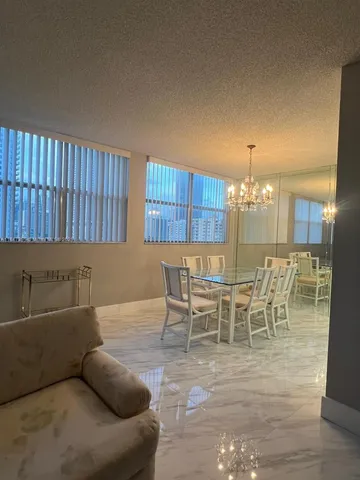 a kitchen with stainless steel appliances kitchen island granite countertop a table chairs sink and cabinets
