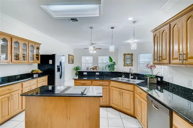 a kitchen with granite countertop a sink a counter top space appliances and cabinets