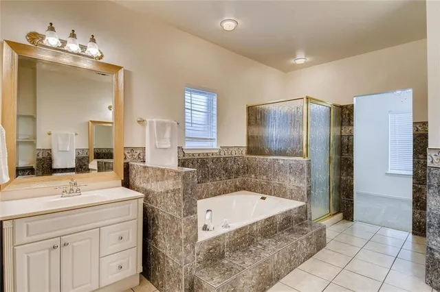 a bathroom with a granite countertop sink mirror and bathtub