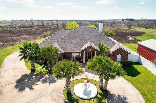 an aerial view of house with yard and ocean view