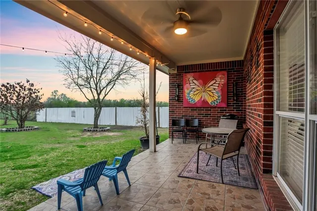 a view of a chairs and table in patio with a backyard