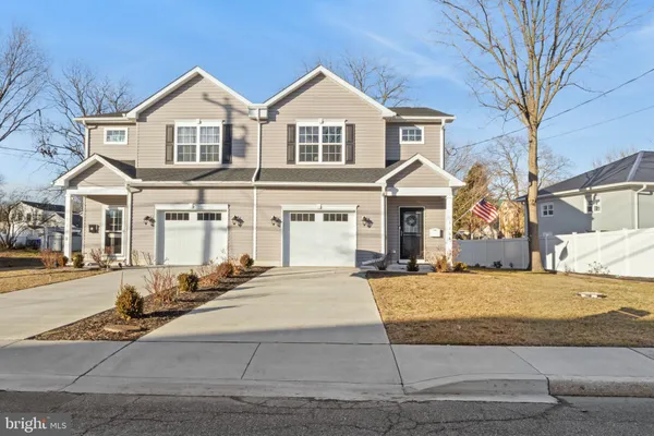 a front view of a house with yard and parking
