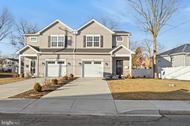 a front view of a house with yard and parking