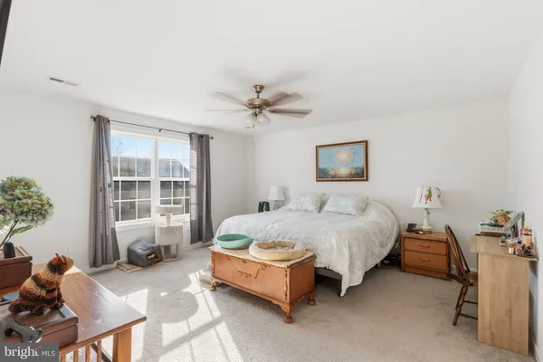 a spacious bedroom with a bed and a window