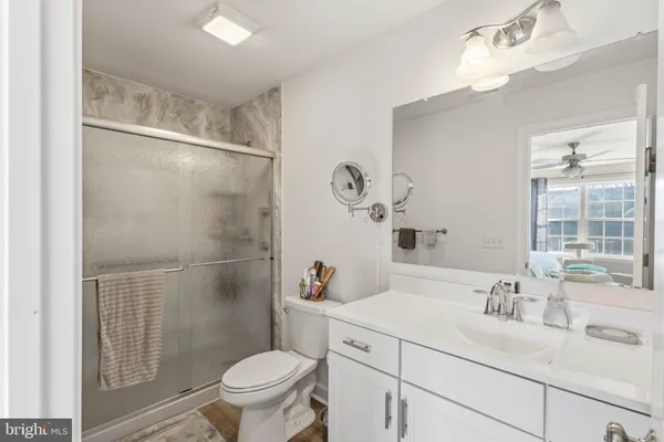 a bathroom with a sink toilet vanity and shower