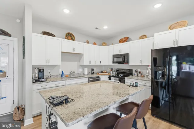 a kitchen with stainless steel appliances granite countertop a sink refrigerator and microwave