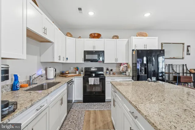 a large kitchen with stainless steel appliances granite countertop a stove and a sink