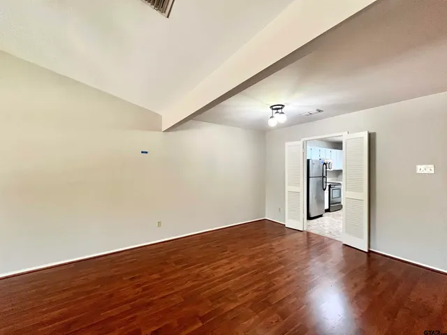 a view of an empty room with wooden floor
