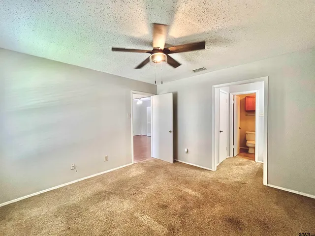 en empty room with ceiling fan and window