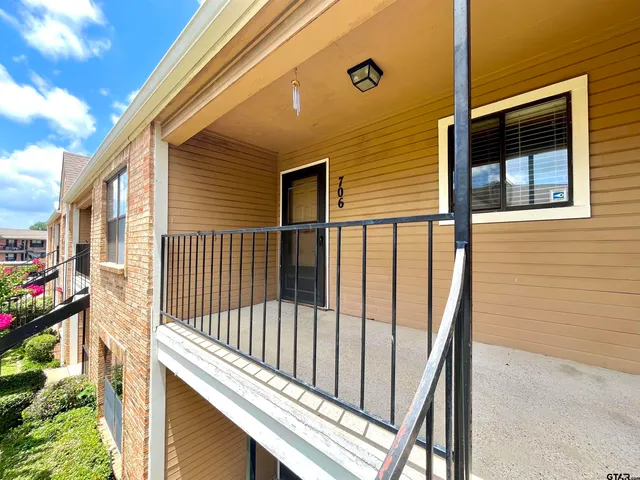 a view of a balcony with wooden floor and fence