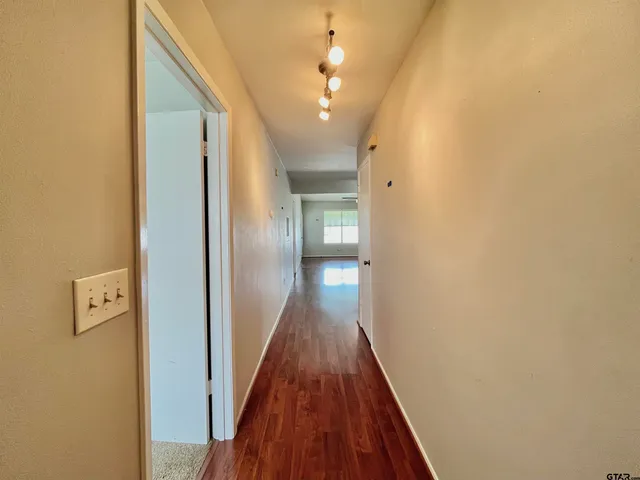 a view of a hallway with wooden floor and staircase