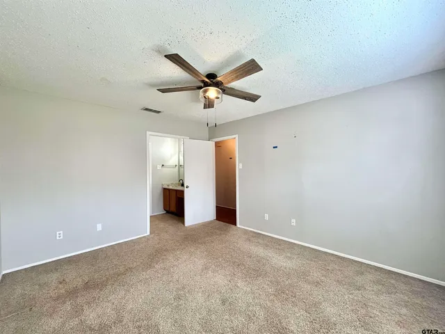 an empty room with fan and windows