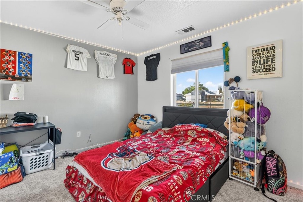 13146 Mohawk Road Apple Valley, CA 92308 - Photo 14 of 15 a bedroom that has a bed and a tv in it