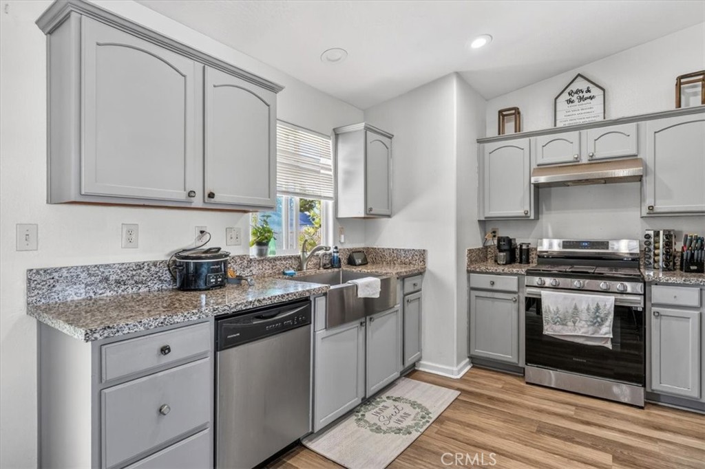 13146 Mohawk Road Apple Valley, CA 92308 - Photo 5 of 15 a kitchen with stainless steel appliances granite countertop a stove sink and cabinets