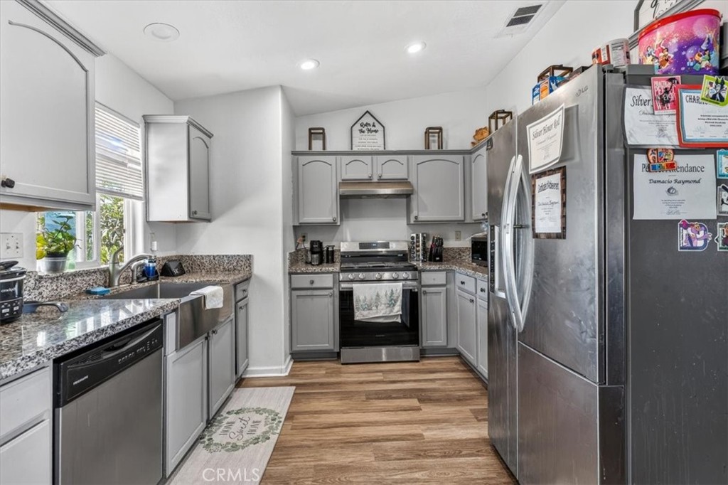 13146 Mohawk Road Apple Valley, CA 92308 - Photo 7 of 15 a kitchen with stainless steel appliances granite countertop a refrigerator stove and sink