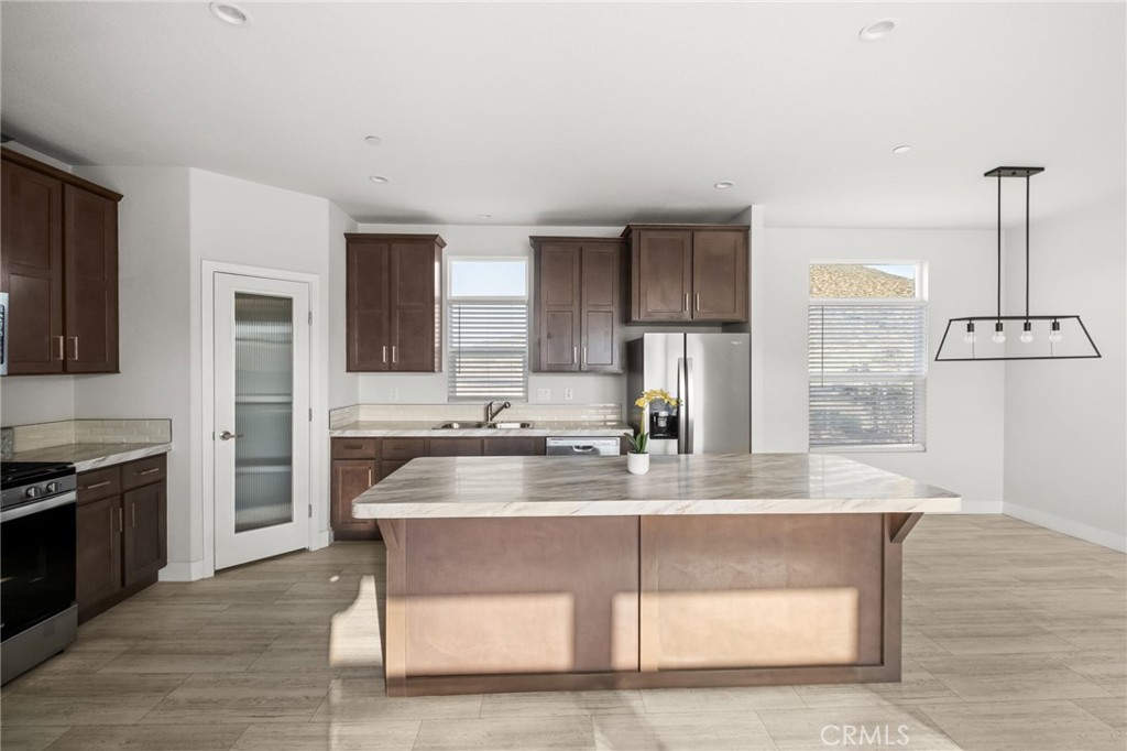 26220 Calvert Avenue Hemet, CA 92545 - Photo 30 of 69 a kitchen with kitchen island granite countertop a sink cabinets and stainless steel appliances