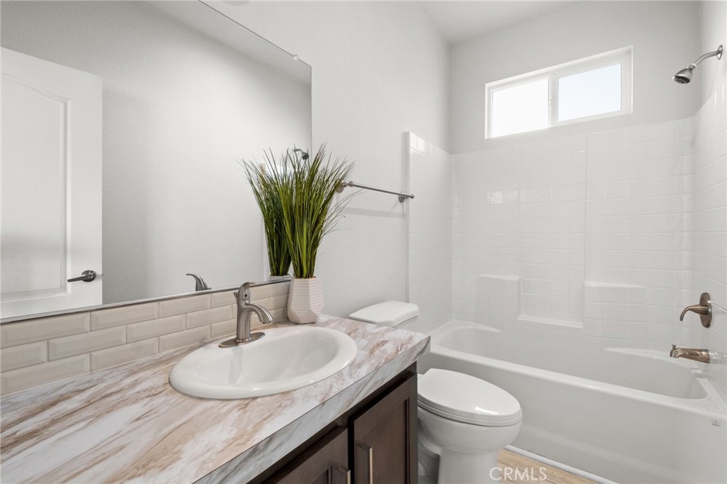 26220 Calvert Avenue Hemet, CA 92545 - Photo 39 of 69 a bathroom with a granite countertop sink a toilet and a mirror