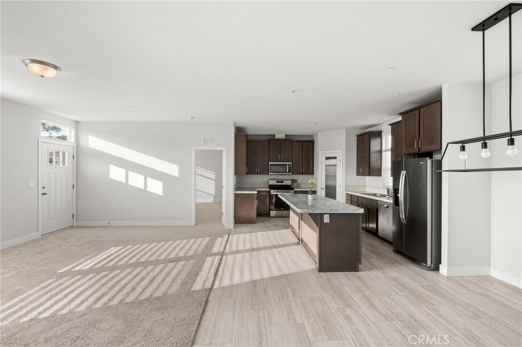 26220 Calvert Avenue Hemet, CA 92545 - Photo 44 of 69 a kitchen with stainless steel appliances a stove top oven a refrigerator cabinets and wooden floor