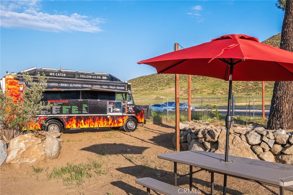 26220 Calvert Avenue Hemet, CA 92545 - Photo 46 of 69 a view of a swimming pool with a table and chairs under an umbrella