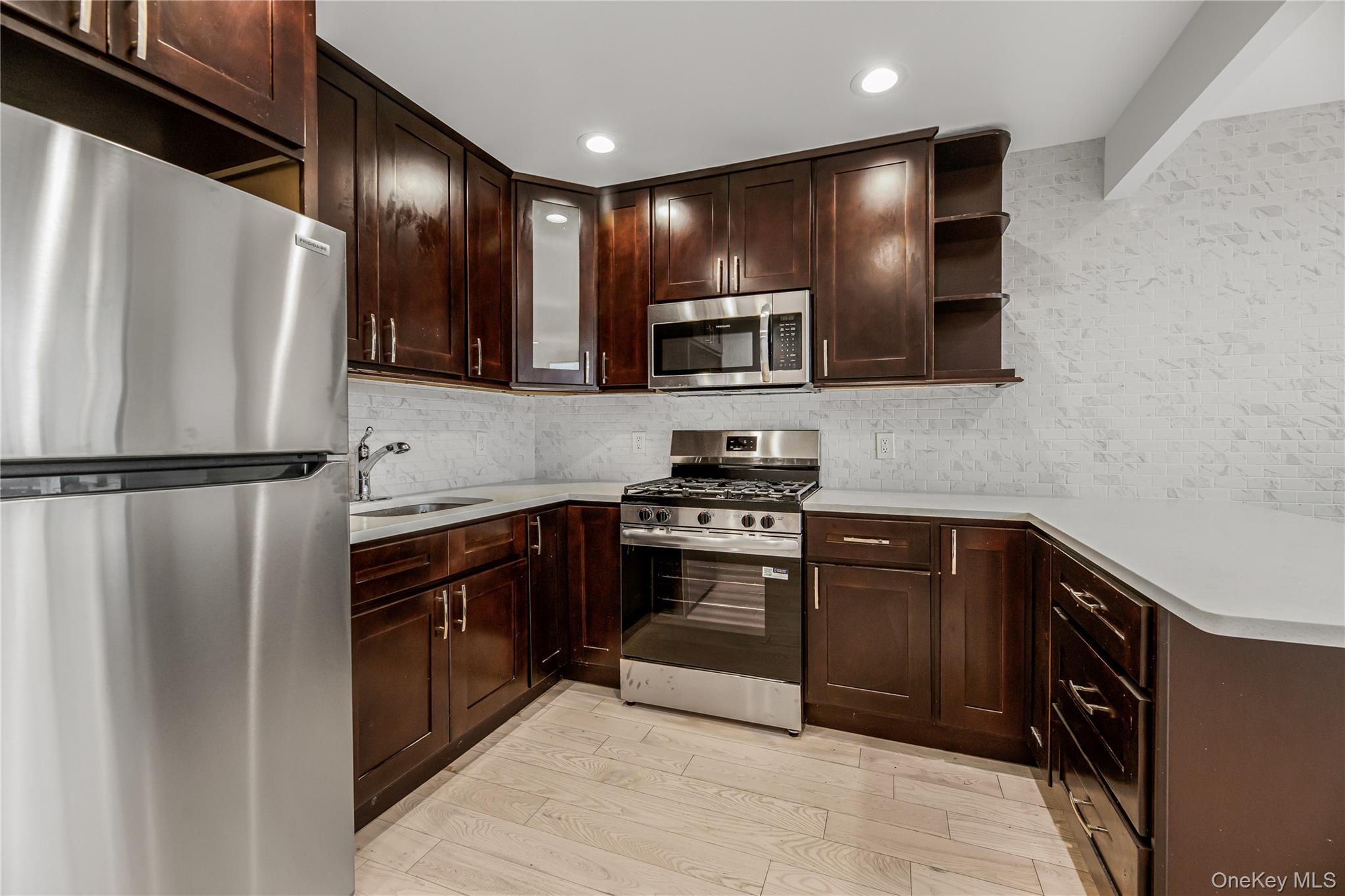 3067 Williamsbridge Road Bronx, NY 10467 - Photo 7 of 29 a kitchen with stainless steel appliances granite countertop a refrigerator and a stove top oven