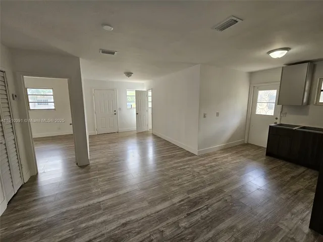 a view of a kitchen with wooden floor and a sink