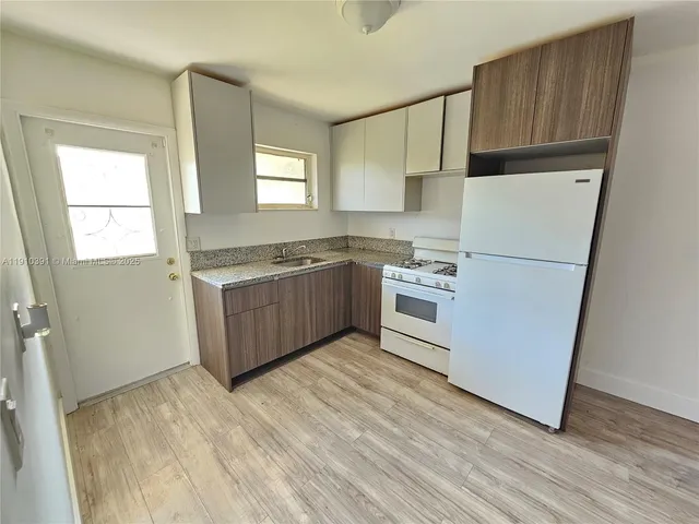 a kitchen with stainless steel appliances a refrigerator sink and cabinets