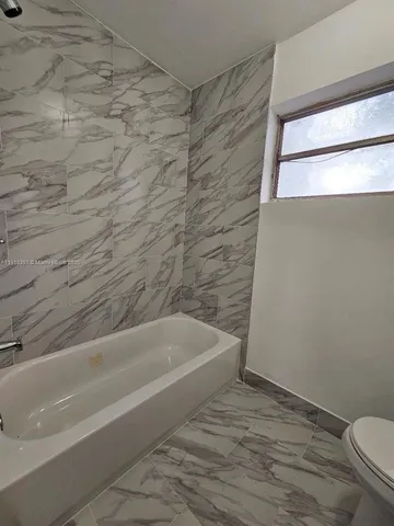 a bathroom with a bathtub and a toilet