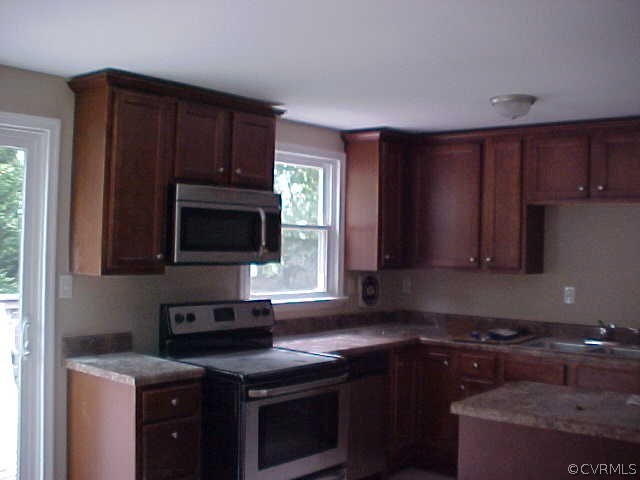 9305 Cason Road Glen Allen, VA 23060 - Photo 4 of 12 a kitchen with granite countertop wooden cabinets and a stove top oven
