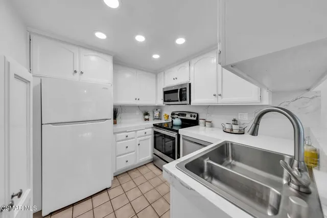 a kitchen with white cabinets and white appliances