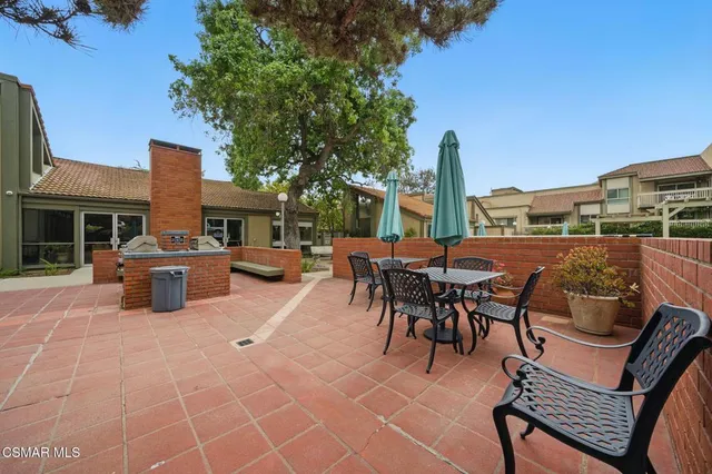 a view of a patio with a dining table and chairs with wooden floor and fence