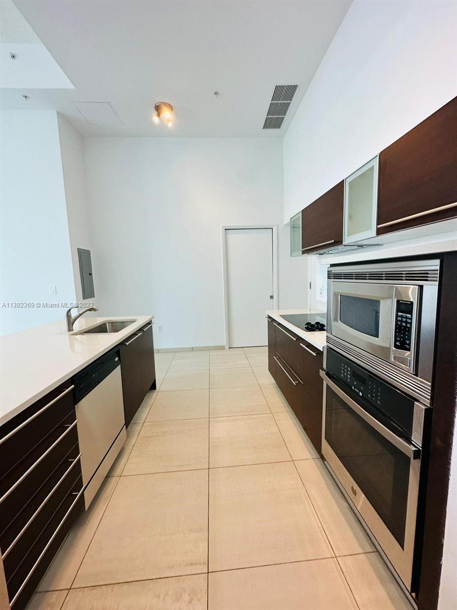 Edgewater Miami, FL 33132 - Photo 13 of 25 a kitchen with stainless steel appliances a stove microwave and sink