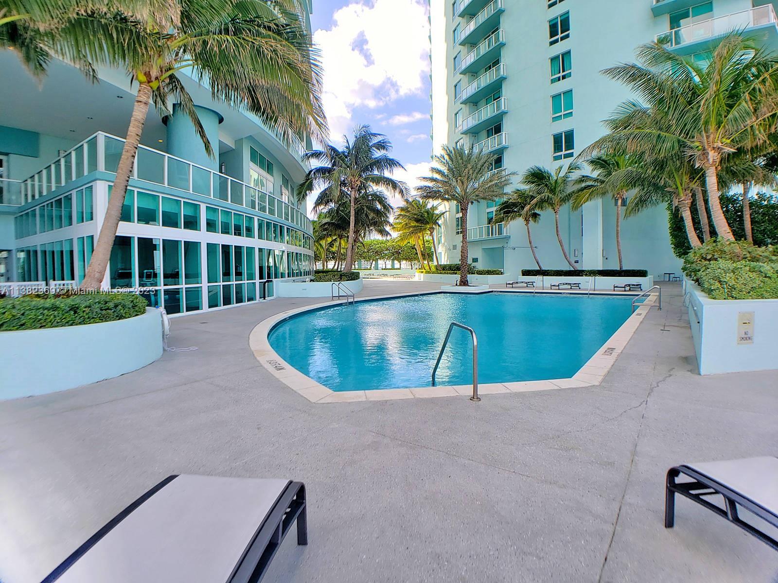 Edgewater Miami, FL 33132 - Photo 7 of 25 a view of a swimming pool with a yard and palm trees