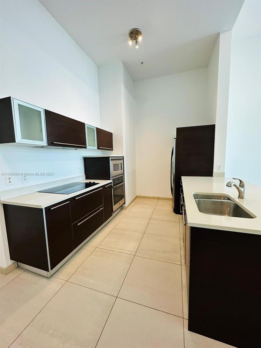 Edgewater Miami, FL 33132 - Photo 10 of 25 a kitchen with stainless steel appliances a sink and a microwave