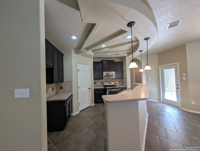 a large kitchen with a large counter top appliances and cabinets