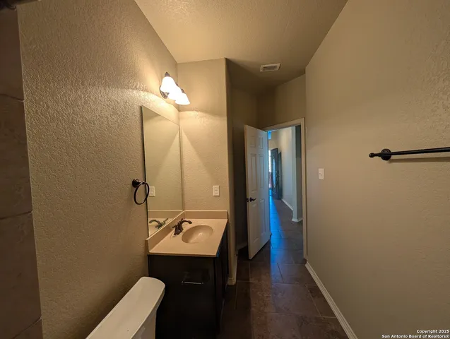 a bathroom with a sink a toilet a mirror and vanity