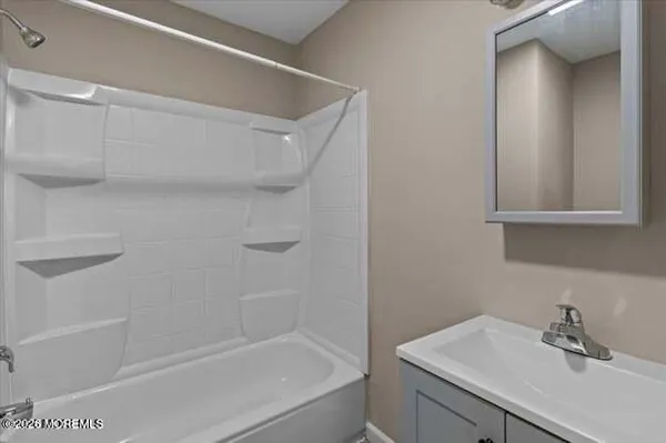 a bathroom with a bathtub sink vanity and a mirror