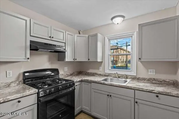 a kitchen with granite countertop cabinets stainless steel appliances and a sink