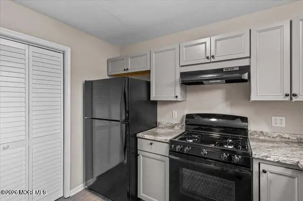 a kitchen with appliances a refrigerator and cabinets