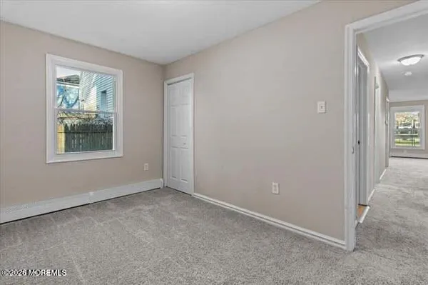 an empty room with windows and closet