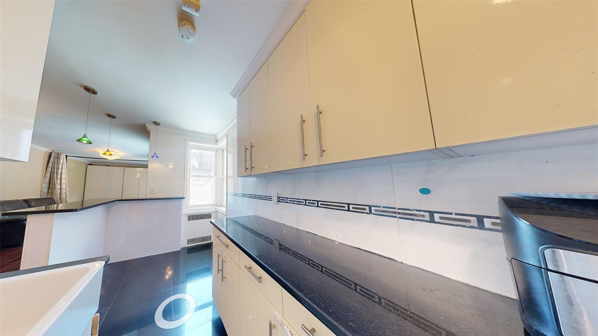 94-10 64th Road, Unit B6 Queens, NY 11374 - Photo 11 of 17 a kitchen with stainless steel appliances a sink stove and cabinets