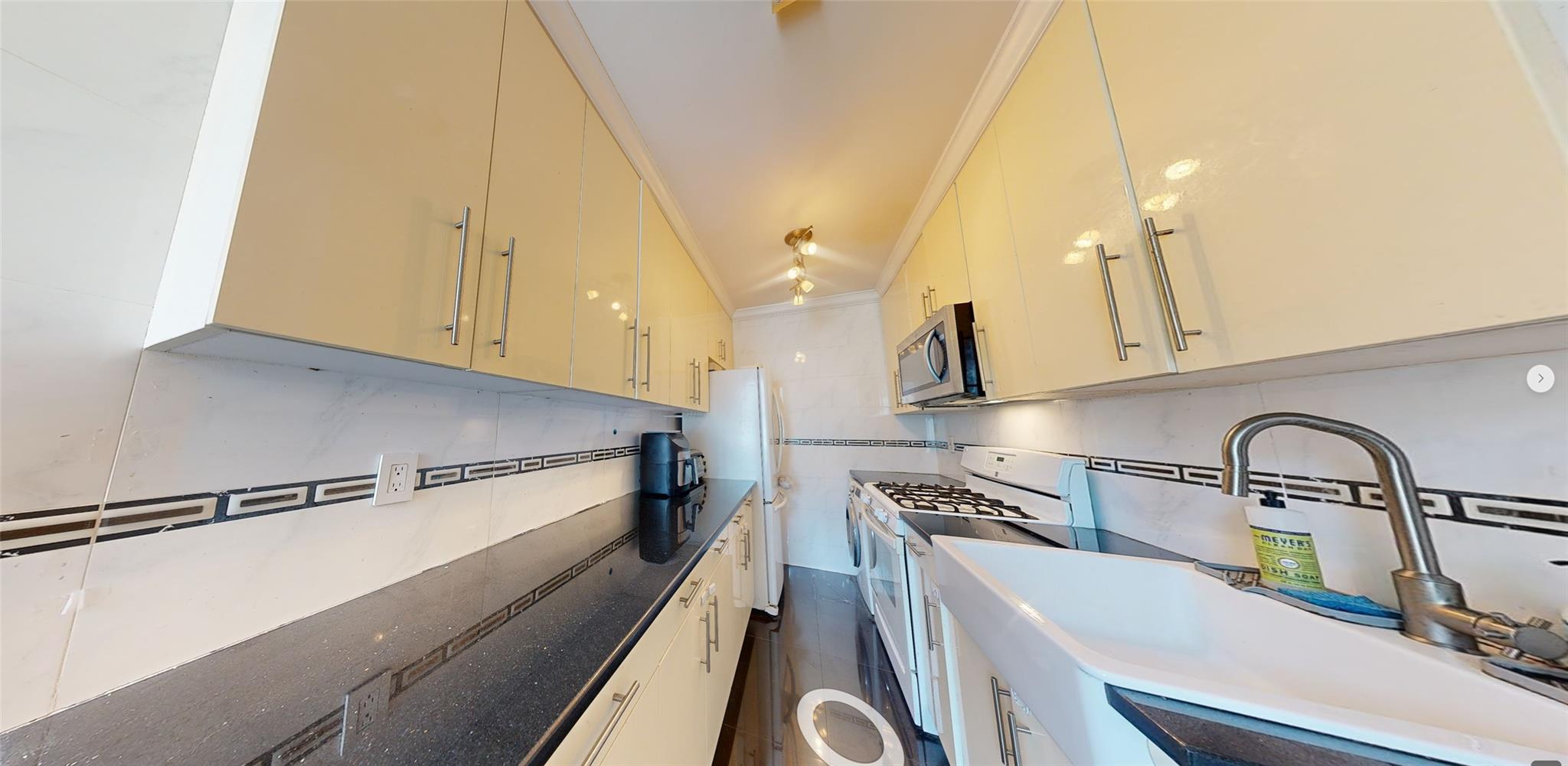94-10 64th Road, Unit B6 Queens, NY 11374 - Photo 12 of 17 a kitchen with a sink and a stove top oven