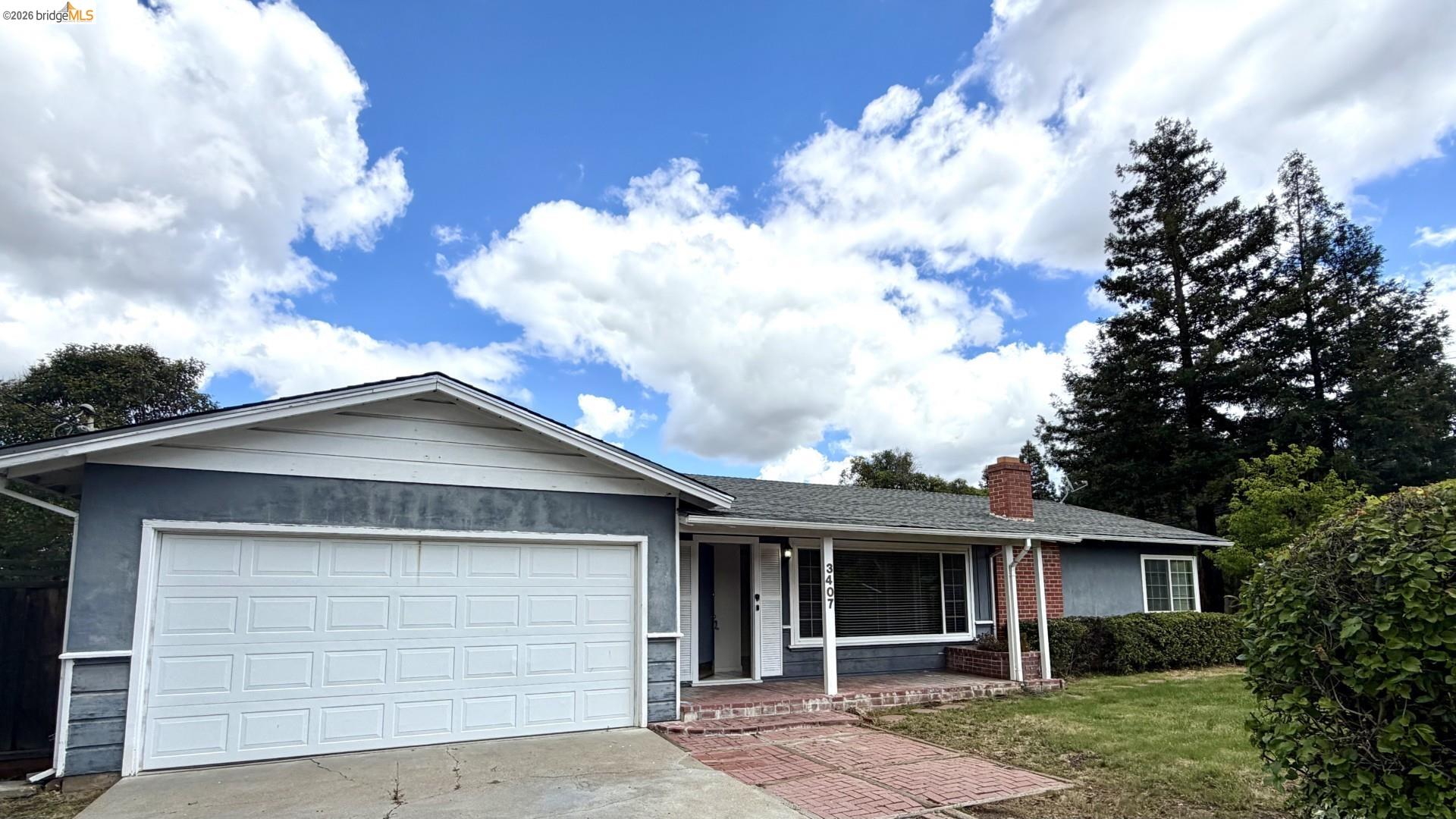 3407 Cowell Road Concord, CA 94518 - Photo 1 of 1 Ranch-style house featuring covered porch, concrete driveway, an attached garage, a chimney, and a front yard