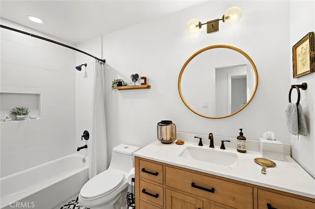 a bathroom with a sink a mirror a toilet and a bathtub